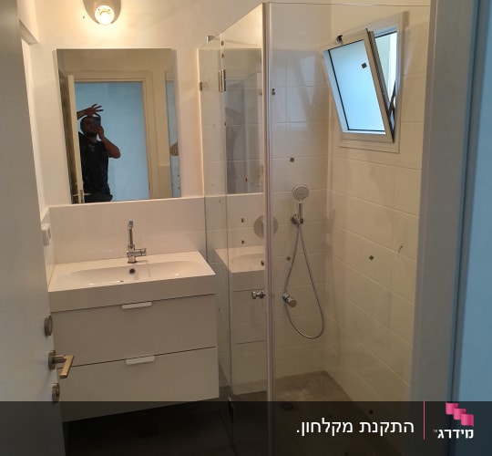 מקלחון זכוכית פינתי מותקן בחדר רחצה מודרני